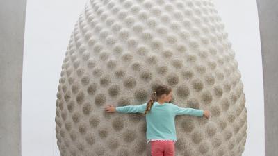 Girl hugging Seed sculpture